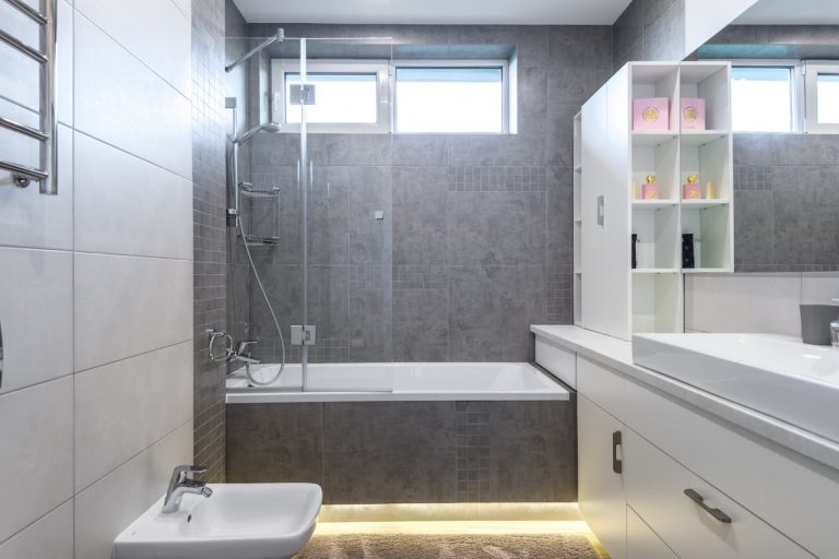Portfolio Contemporary bathroom featuring sleek gray tiles, bathtub, shower, and vanity.